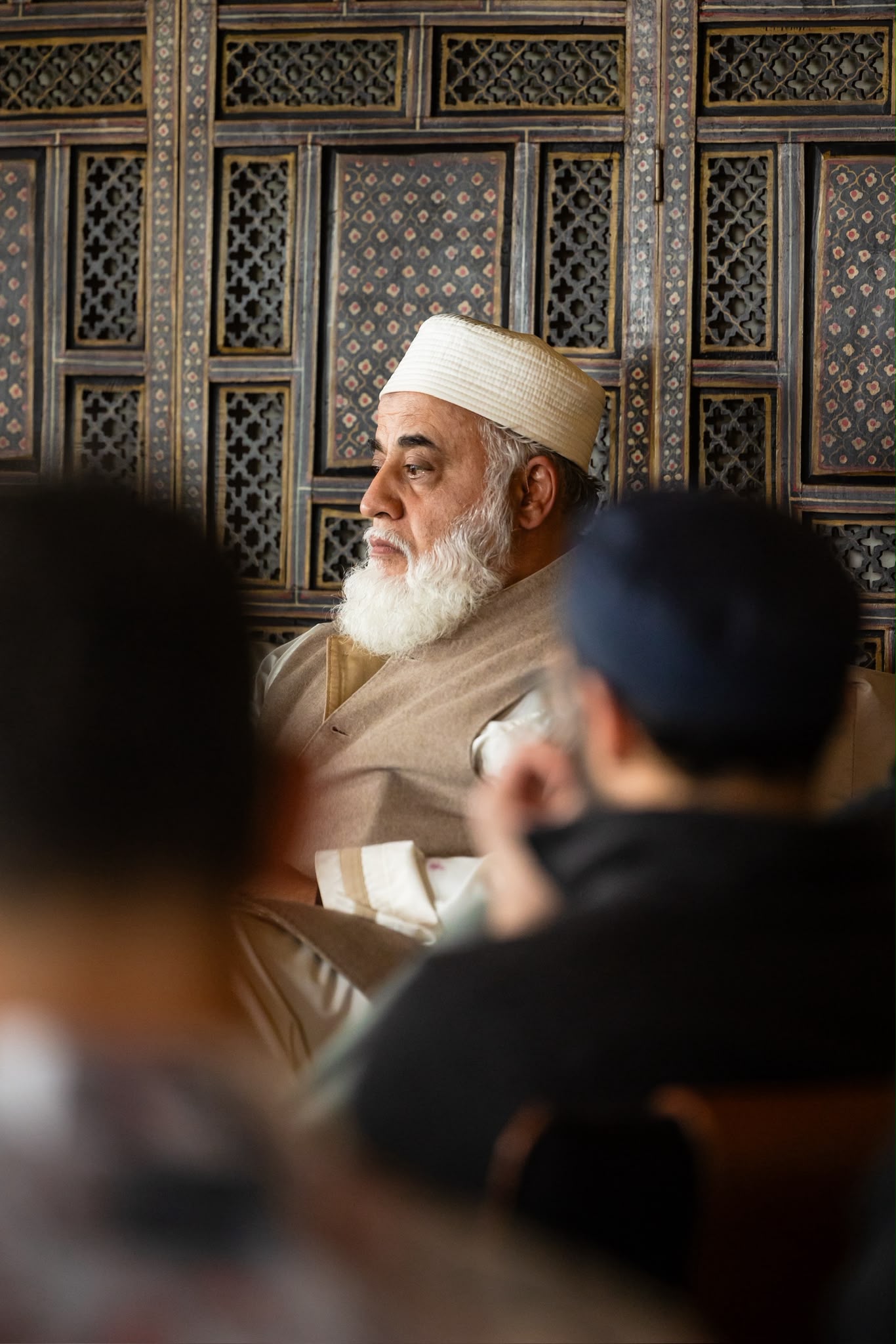 A scholar seated before the dīwān screen